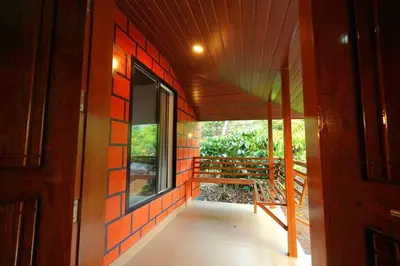 a room with a window and a bench on a porch at Entire Villa at the Heart of the Wayanad Forest. in Kutta