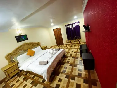 a bedroom with a large bed and a red wall at MAGIC MIST RESORT in Ooty