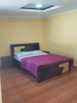 a bedroom with a large bed with a purple blanket at MAGIC MIST RESORT in Ooty