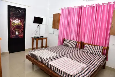 a bedroom with a bed with a pink curtain at Oceangreen cottage in Kannur