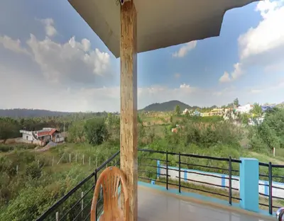 a balcony of a house with a view of the countryside at Coorg Dream Land Homestay by StayApart, Kushalnagar in Kushālnagar