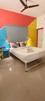 a large bed in a room with colorful walls at goSTOPS Coorg in Madikeri