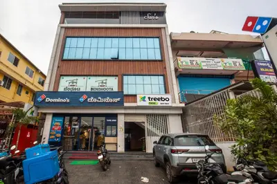 a building with a car parked in front of it at Treebo Sans Sarav Kushalnagar, 10 mins to Nisargadhama Island in Madikeri