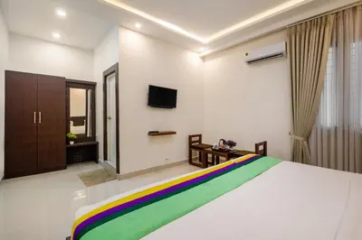 a bedroom with a bed with a rainbow blanket at Treebo Sans Sarav Kushalnagar, 10 mins to Nisargadhama Island in Madikeri
