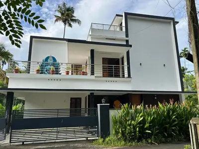 a white house with a balcony and a palm tree at Bachan's Casa The Private Pool Villa Cherai in Cherai Beach