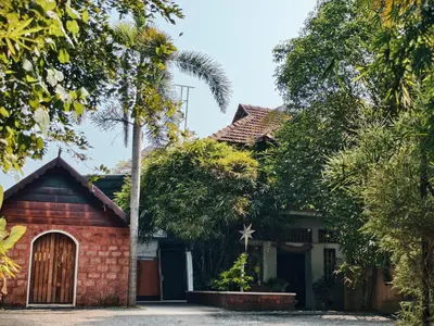 a red brick house with a palm tree at Ambadi's villa -Lake view resort in Pallipuram