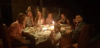 a group of people sitting around a dinner table at Ambadi's villa -Lake view resort in Pallipuram