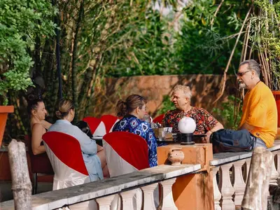 a group of people sitting at a table in a restaurant at Ambadi's villa -Lake view resort in Pallipuram