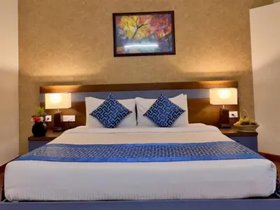 a bedroom with a large bed with blue and white pillows at Adrak Mountain Mist Forest Resort in Pulpally