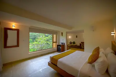 a bedroom with a large bed and a window at Maple Ash Resort in Vayittiri