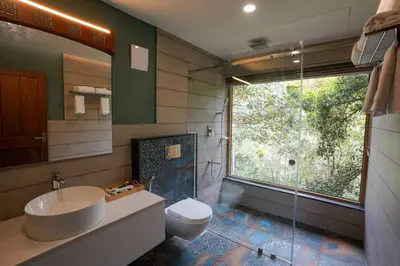 a bathroom with a sink and a toilet and a window at Maple Ash Resort in Vayittiri