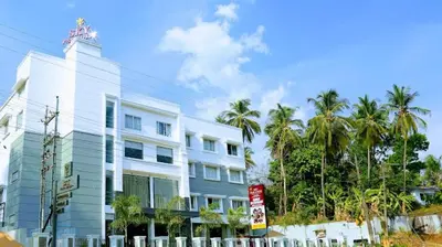 a white building with palm trees in front of it at HOTEL SKY PARADISE in Iritti