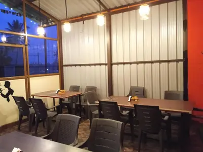 a dining room with tables and chairs and windows at Leo's Residency Coorg in Kushālnagar
