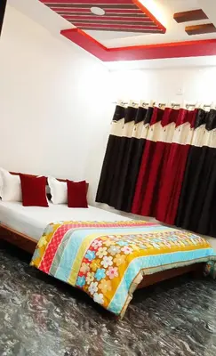 a bedroom with two beds with a colorful blanket at Leo's Residency Coorg in Kushālnagar