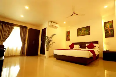 a bedroom with a large bed and a window at ORFILA INN Airport Hotel in Angamali