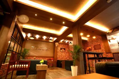a restaurant with a bar with a brick wall at ORFILA INN Airport Hotel in Angamali