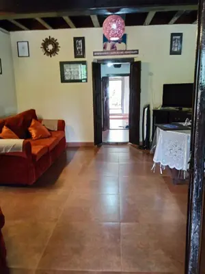 a living room with a couch and a table at Sardar Bahadur's Heritage Bungalow Estate Stay in Napoklu