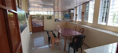 a dining room with a wooden table and chairs at Honeybee Homestay by The Jungle Stay Groups in Vālpārai