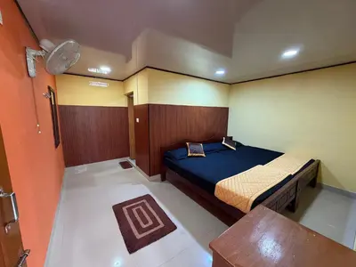 a small bedroom with a bed and a table at Honeybee Homestay by The Jungle Stay Groups in Vālpārai