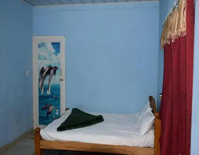 a bedroom with a bed with a painting on the wall at Green Coorg by StayApart, Madikeri in Madikeri