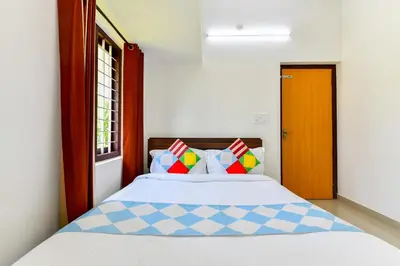 a bedroom with a bed with colorful pillows at CentreHome Villa Wayanad in Meenangadi