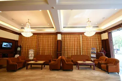 a waiting room with couches and tables and chandeliers at RATHNA RESIDENCY in Coimbatore