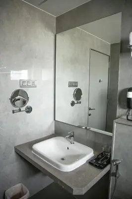 a bathroom with a sink and a large mirror at RATHNA RESIDENCY in Coimbatore