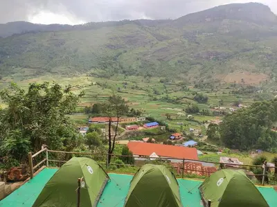 two green tents sitting on top of a mountain at Misty Mountains Holiday Homes in Vattavada