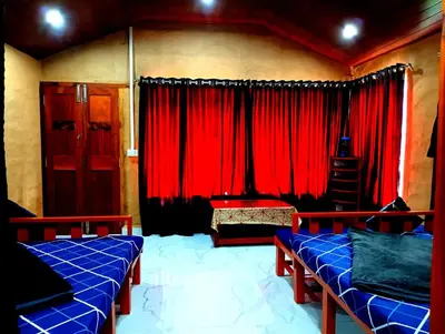 a room with two beds and red curtains at Misty Mountains Holiday Homes in Vattavada