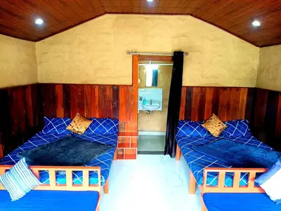 a room with two beds with blue sheets and a mirror at Misty Mountains Holiday Homes in Vattavada