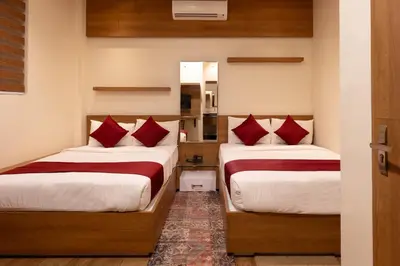a bedroom with two beds with red pillows at MEDLEY REGENCY in Palakkad