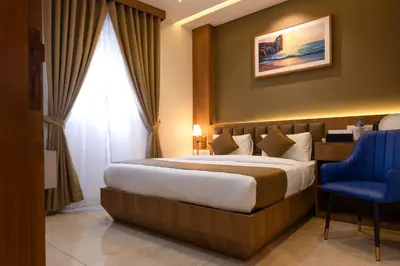 a hotel room with a bed and a blue chair at MEDLEY REGENCY in Palakkad