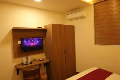 a room with a bed and a cabinet with a tv at MEDLEY REGENCY in Palakkad