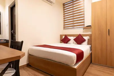 a bedroom with a bed with a desk and a window at MEDLEY REGENCY in Palakkad