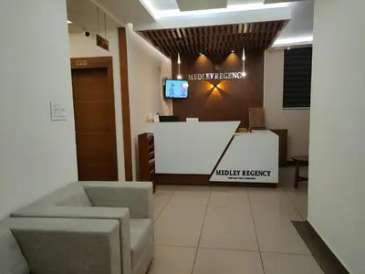 a waiting room with two chairs and a reception desk at MEDLEY REGENCY in Palakkad