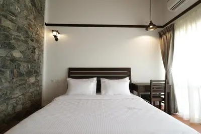 a bedroom with a large bed and a table at Havon Plantation Resorts in Varagampadi