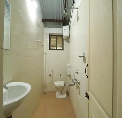 a bathroom with a toilet and a sink at Havon Plantation Resorts in Varagampadi