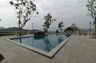 a swimming pool in the middle of a resort at Havon Plantation Resorts in Varagampadi