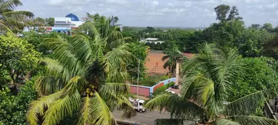 a group of palm trees in front of a building at Yelza Hotel and Residence in Alwaye