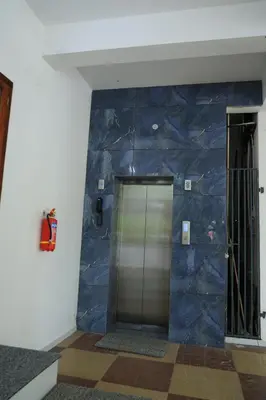 a lobby with a blue wall and a elevator at Yelza Hotel and Residence in Alwaye