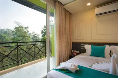 a bedroom with a bed and a balcony at Amrezy Resort and Spa by Stride, Wayanad in Vythiri