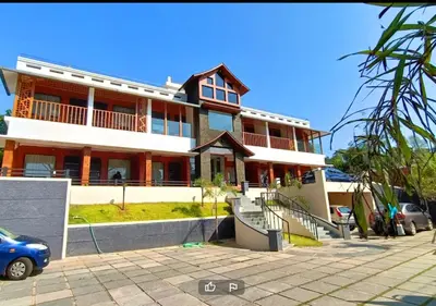 a building with a blue car parked in front of it at The Lavender Resort Waynad in Vaduvanchal