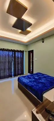 a bedroom with a blue bed and a ceiling fan at Rose Garden Enclave for Families & Executives in Ooty