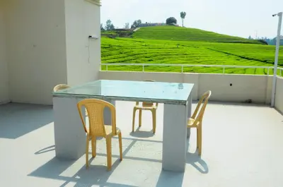 a table and two chairs sitting on a balcony at Rose Garden Enclave for Families & Executives in Ooty