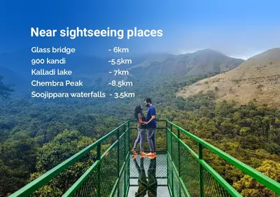 a man and woman standing on top of a viewing platform in the mountains at Skyfall 900kandi in Meppādi