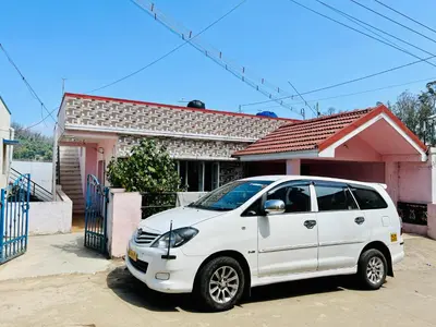 a white car parked in front of a house at Down House 19 Ooty - TEYT HOLIDAYS in Ooty