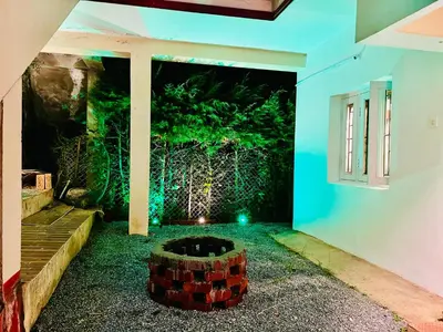 an indoor garden with a fire pit in the middle of a house at Down House 19 Ooty - TEYT HOLIDAYS in Ooty