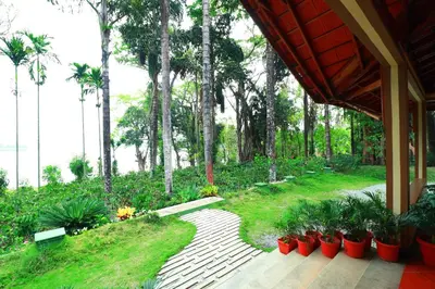 a garden with a wooden walkway with plants and trees at SaffronStays Coorg Toddy Farms, Coorg in Madikeri
