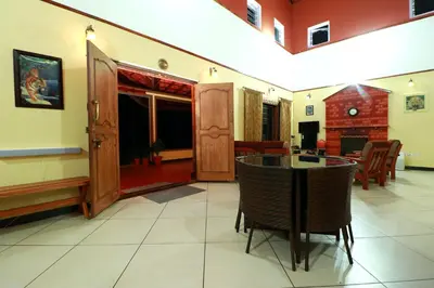 a living room with a table and chairs at SaffronStays Coorg Toddy Farms, Coorg in Madikeri