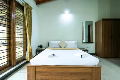 a bedroom with a bed with white sheets and a window at SaffronStays Coorg Toddy Farms, Coorg in Madikeri